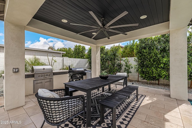 view of patio / terrace with ceiling fan, exterior kitchen, outdoor dining area, a fenced backyard, and a grill