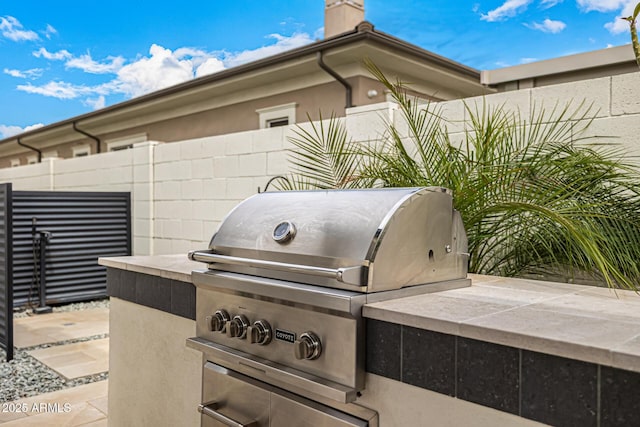 view of patio / terrace with area for grilling, exterior kitchen, and fence