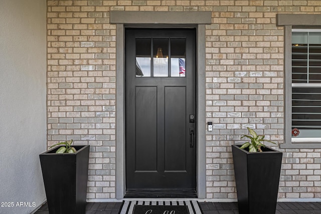 property entrance featuring brick siding