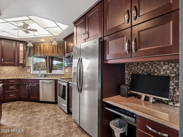 kitchen with sink, light tile patterned floors, ceiling fan, appliances with stainless steel finishes, and decorative backsplash