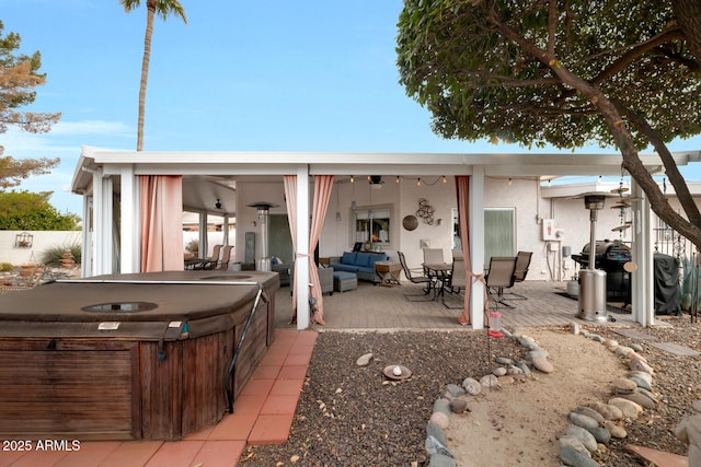 back of house featuring a patio area, a hot tub, and outdoor lounge area