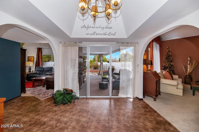 foyer with dark colored carpet and a chandelier