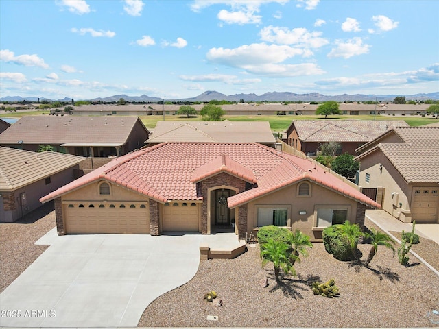 11320 E Newcastle Ave, Mesa, AZ 85209 - mediterranean / spanish house with an attached garage, stone siding, concrete driveway, a tiled roof, and a mountain view