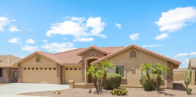 11320 E Newcastle Ave, Mesa, AZ 85209 - mediterranean / spanish home featuring a garage, stone siding, stucco siding, and driveway