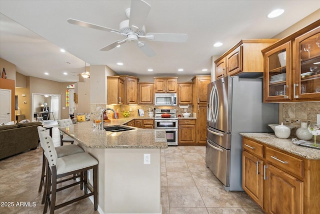 11320 E Newcastle Ave, Mesa, AZ 85209 - kitchen with stainless steel appliances, a sink, a peninsula, a ceiling fan, and tasteful backsplash