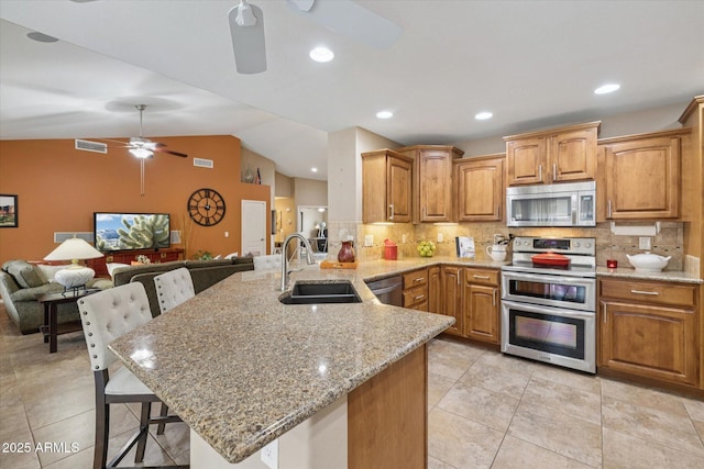 11320 E Newcastle Ave, Mesa, AZ 85209 - kitchen with appliances with stainless steel finishes, ceiling fan, a sink, a breakfast bar area, and a peninsula