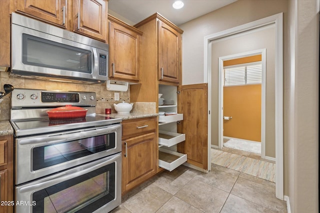 11320 E Newcastle Ave, Mesa, AZ 85209 - kitchen featuring appliances with stainless steel finishes, decorative backsplash, light stone countertops, brown cabinets, and recessed lighting
