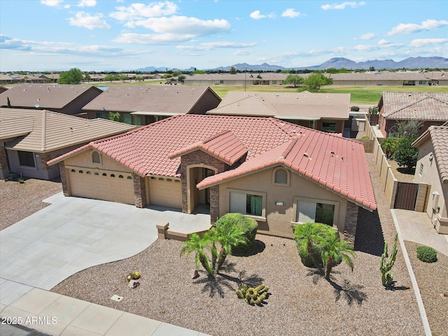 11320 E Newcastle Ave, Mesa, AZ 85209 - mediterranean / spanish-style home with stone siding, an attached garage, a tile roof, concrete driveway, and stucco siding