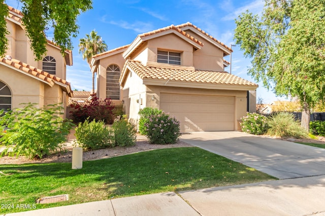 mediterranean / spanish-style home with a garage and a front yard