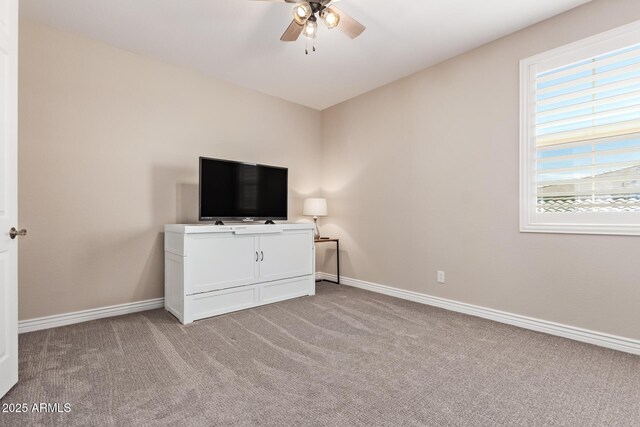 unfurnished bedroom featuring light colored carpet, baseboards, and ceiling fan