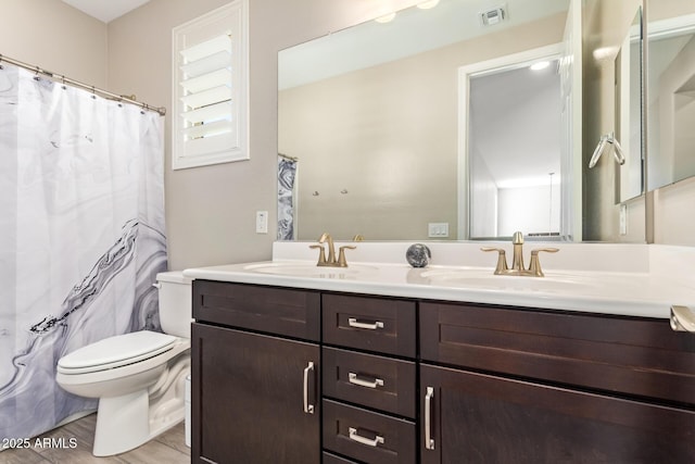 full bathroom with toilet and double vanity