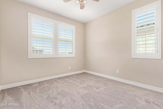 spare room with healthy amount of natural light, carpet, a ceiling fan, and baseboards