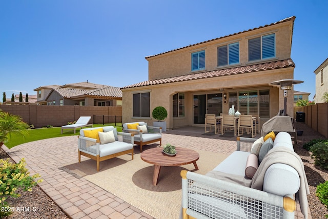 rear view of house featuring outdoor lounge area, a patio area, a fenced backyard, and stucco siding