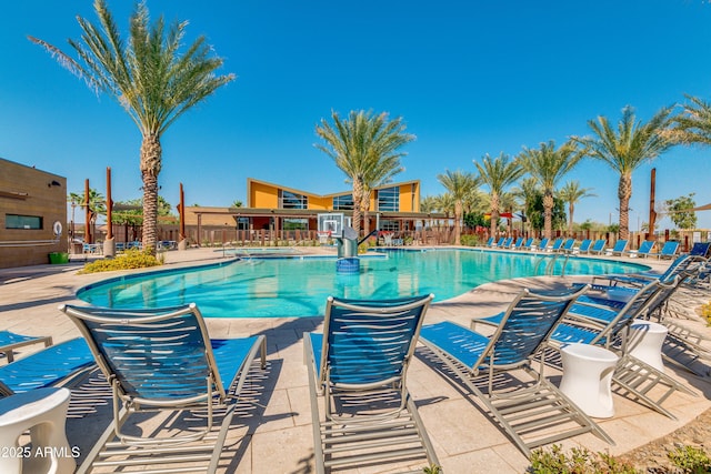 community pool featuring fence and a patio