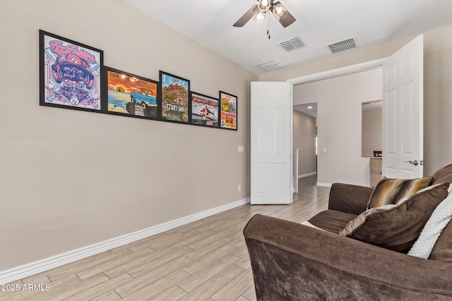 sitting room featuring ceiling fan, baseboards, and light wood-type flooring
