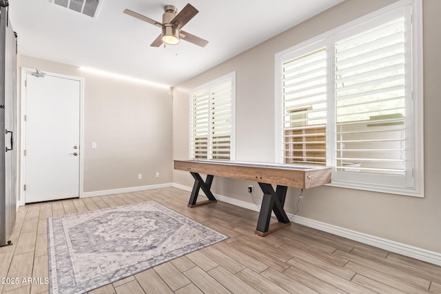 foyer entrance with wood finished floors, a ceiling fan, and baseboards