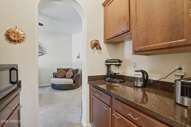 kitchen featuring carpet flooring and dark stone counters