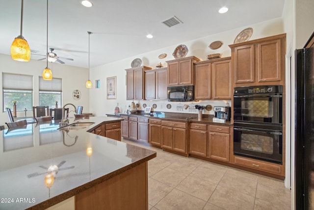 kitchen featuring pendant lighting, black appliances, a center island with sink, sink, and light tile patterned flooring