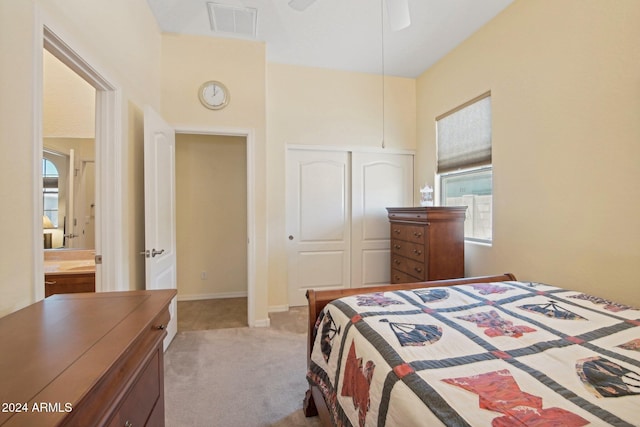 bedroom with ceiling fan, a closet, and light colored carpet