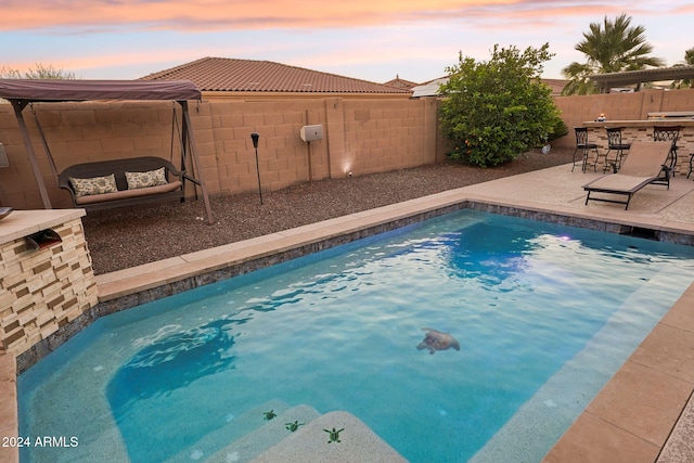 pool at dusk with a patio