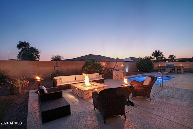 patio terrace at dusk with a fenced in pool and an outdoor living space with a fire pit