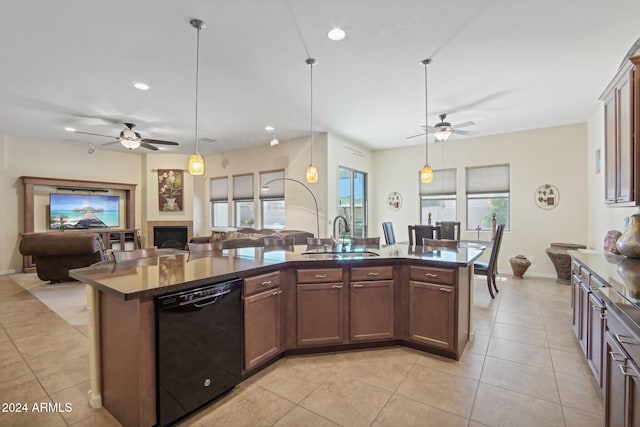 kitchen with hanging light fixtures, black dishwasher, a kitchen island with sink, and ceiling fan