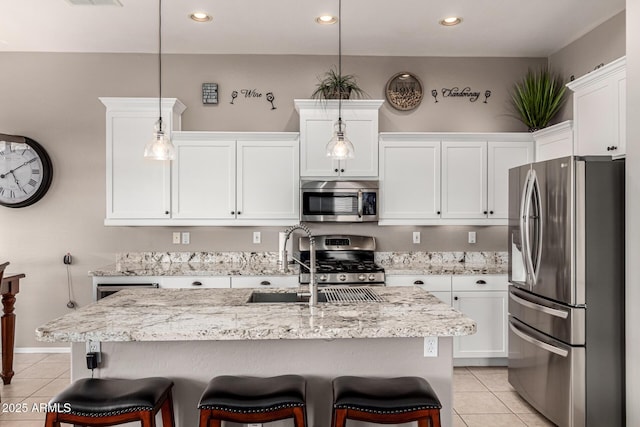 kitchen with appliances with stainless steel finishes, light tile patterned floors, a sink, white cabinets, and recessed lighting