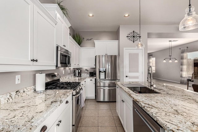 kitchen featuring stainless steel appliances, a sink, white cabinets, recessed lighting, and pendant lighting