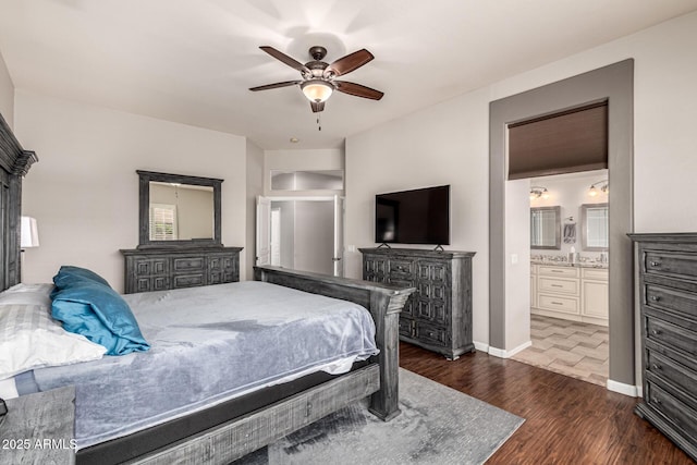 bedroom with dark wood-style flooring, connected bathroom, a ceiling fan, and baseboards