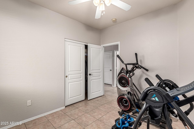 exercise area featuring ceiling fan, light tile patterned flooring, and baseboards