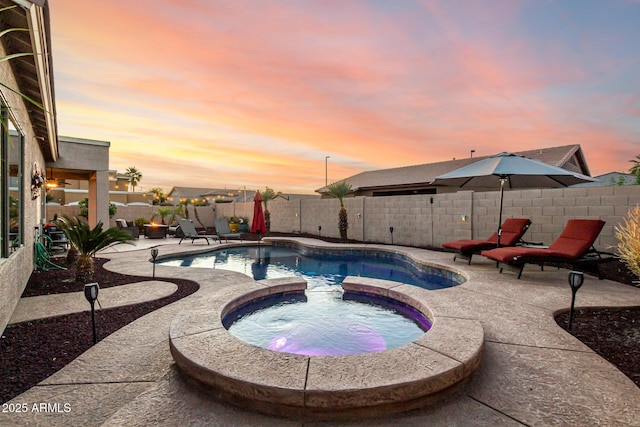 view of swimming pool with a patio, a fenced backyard, and a pool with connected hot tub