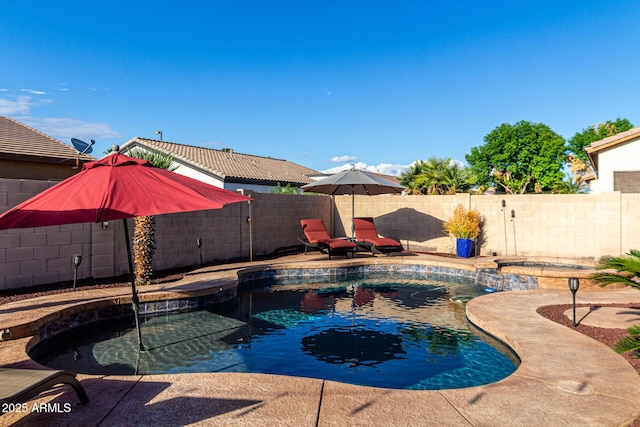 view of swimming pool with a fenced backyard and a pool with connected hot tub