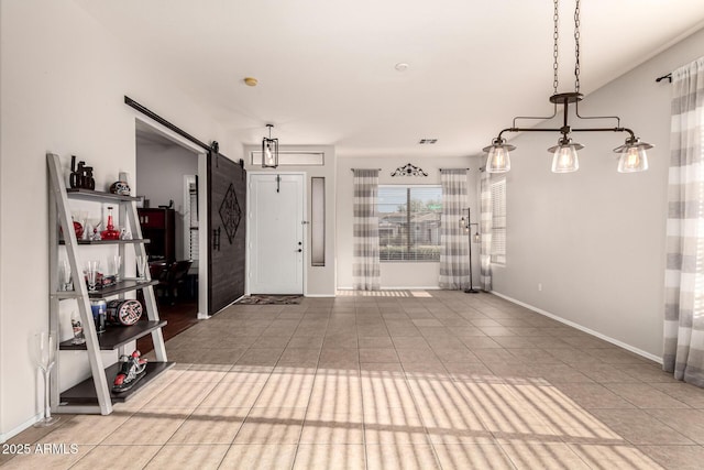 entrance foyer with a barn door, baseboards, and tile patterned floors