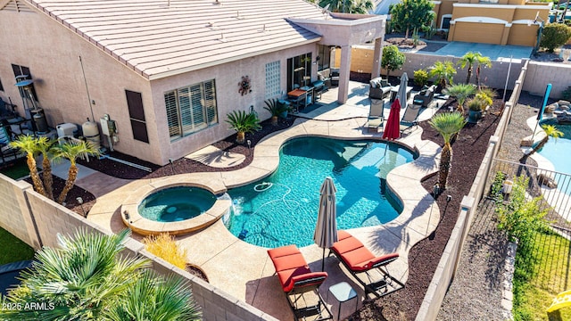 view of pool with a fenced backyard, a patio, and a pool with connected hot tub