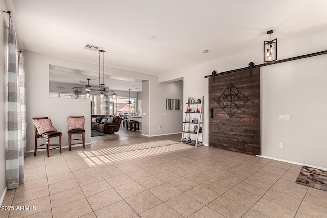 living room featuring light tile patterned flooring, baseboards, a ceiling fan, and a barn door