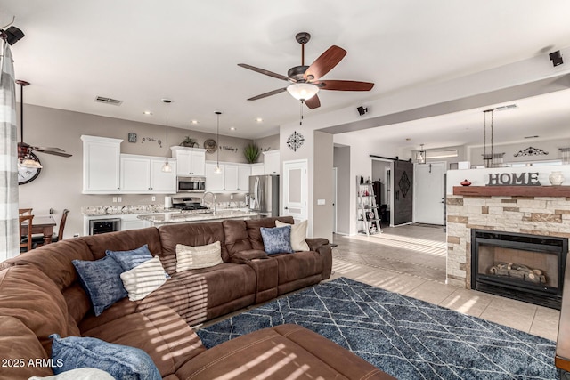 living area featuring a ceiling fan, a barn door, recessed lighting, wine cooler, and light tile patterned floors