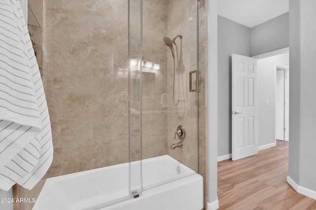 bathroom featuring wood-type flooring and combined bath / shower with glass door