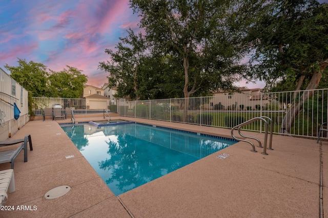 pool at dusk with a patio