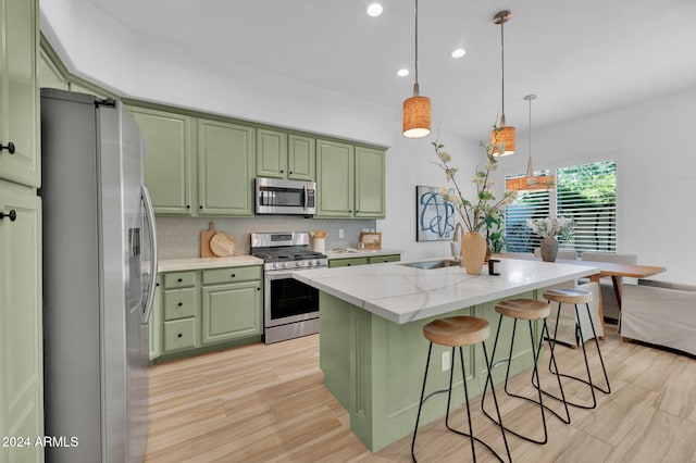 kitchen featuring backsplash, appliances with stainless steel finishes, green cabinets, and hanging light fixtures