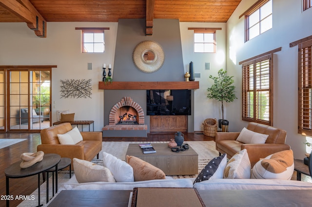 living room featuring hardwood / wood-style floors, a fireplace, wooden ceiling, and beamed ceiling