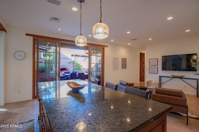 kitchen featuring pendant lighting, a center island, and dark stone counters