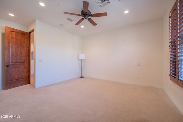 spare room featuring ceiling fan and light carpet