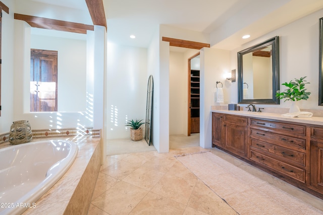 bathroom featuring vanity and a relaxing tiled tub