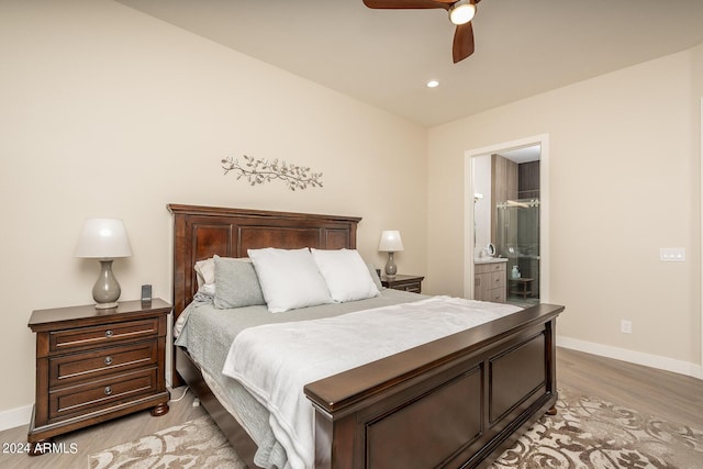 bedroom with ceiling fan, light hardwood / wood-style flooring, and ensuite bath