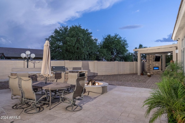 view of patio / terrace with an outdoor fire pit and an outdoor fireplace