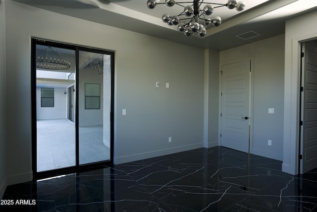 empty room with an inviting chandelier and a raised ceiling