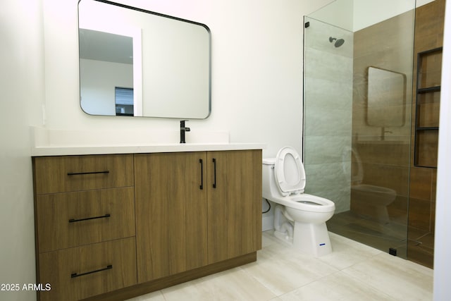 bathroom featuring vanity, a tile shower, tile patterned floors, and toilet