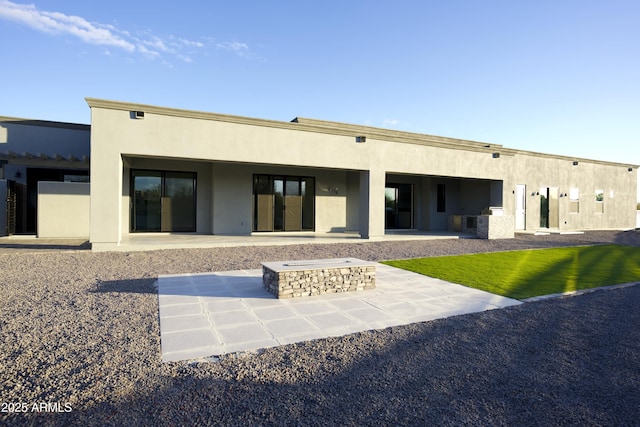 back of property with a patio area and an outdoor fire pit