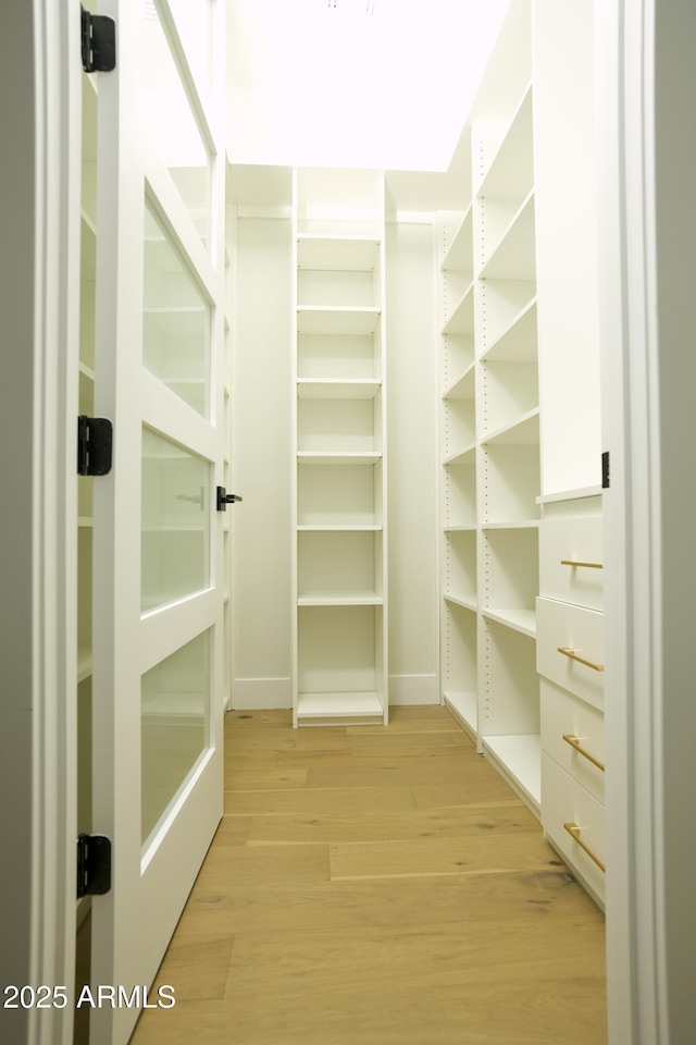 spacious closet with light hardwood / wood-style floors