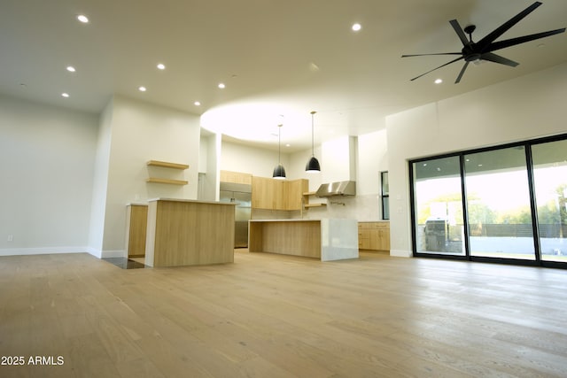 kitchen featuring light hardwood / wood-style flooring, built in refrigerator, hanging light fixtures, a kitchen island, and light brown cabinetry